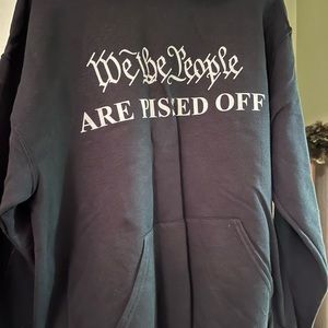 Men’s black pullover hoodie, with front pockets. We The People Are Pissed Off